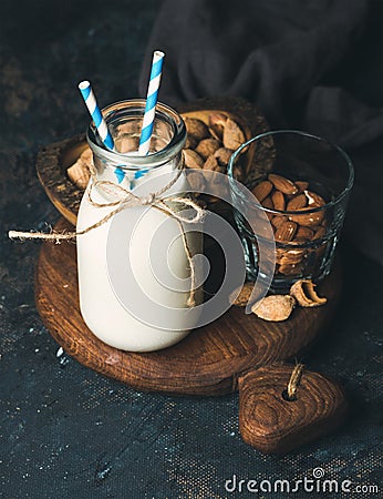 Fresh almond milk in glass bottle served with almonds Stock Photo