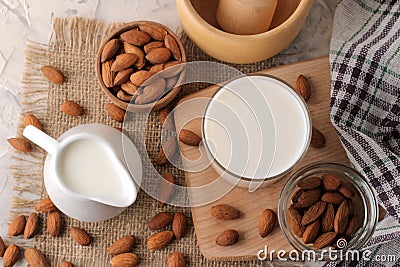 Fresh almond milk in milk jug and almond nuts. top view on a light background Stock Photo