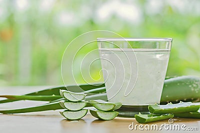 fresh aloe vera leaves and aloe vera juice in glass on wooden ba Stock Photo