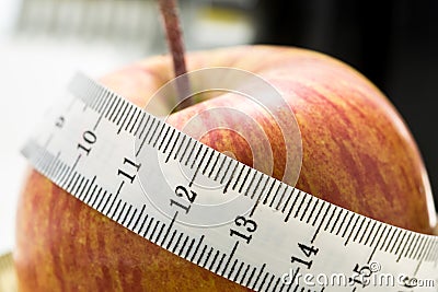 Fresh apple wrapped in a tape measure Stock Photo