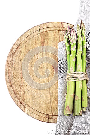 Fresh asparagus on wooden board with kitchen towel Stock Photo