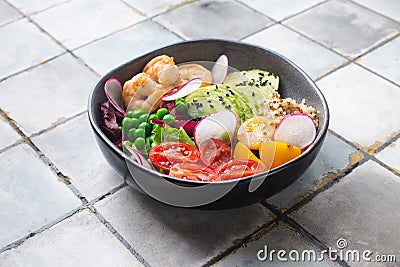 Fresh Avocado, shrimps salad with green pies, cherry tomatoes, herbs and olive oil, lemon dressing Stock Photo