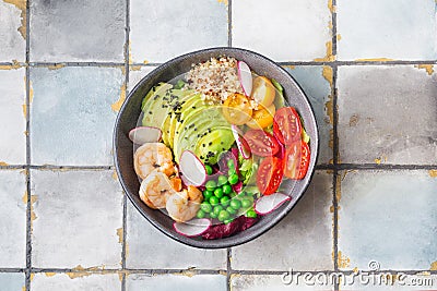 Fresh Avocado, shrimps salad with green pies, cherry tomatoes, herbs and olive oil, lemon dressing Stock Photo