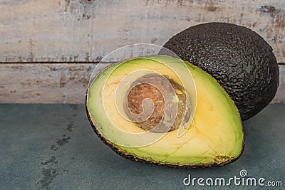 Fresh avocado sliced over vintage background close up. Ripe green avocado fruit on cement board. Stock Photo