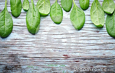 Fresh Baby spinach leaves on blue wooden background. Top view with copy space, horizontal frame. Healthy, Ecology Stock Photo