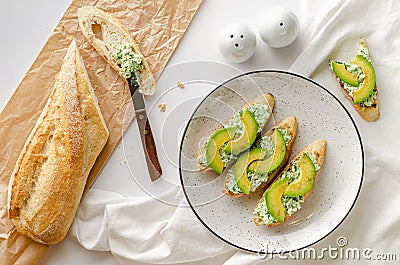Fresh baguette with ricotta, spinach and avocado. Healthy snack concept. Stock Photo