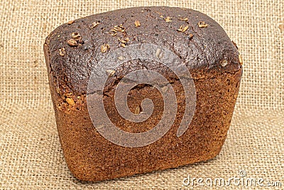 Fresh baked dark bread on jute Stock Photo