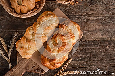 Fresh baked goods - delicious wicker buns on a wooden background with copy space Stock Photo