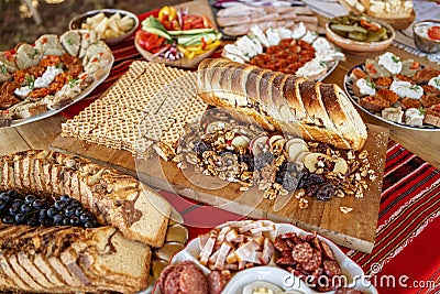 Fresh baked sweet bread and autumn nuts and apples surrounded by traditional food on a table at a local brunch in Romania Stock Photo