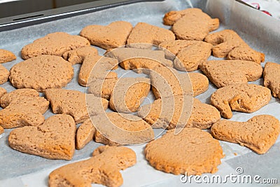 Fresh baking cookies of different shapes on a baking sheet close-up Stock Photo