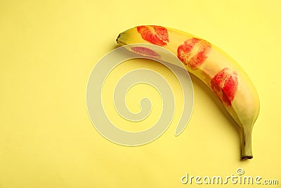 Fresh banana with red lipstick marks on yellow background. Oral sex concept Stock Photo