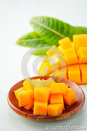 Fresh and beautiful mango fruit with sliced diced mango chunks on a light blue background, copy spacetext space Stock Photo