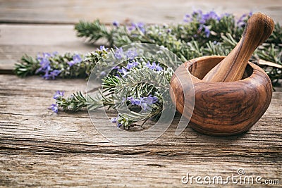 Fresh blooming rosemary and a mortar on a wooden table, copy space Stock Photo