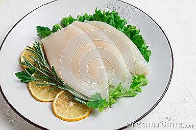 Fresh body, squid, raw, three carcasses, top view, no people , on a plate, Stock Photo