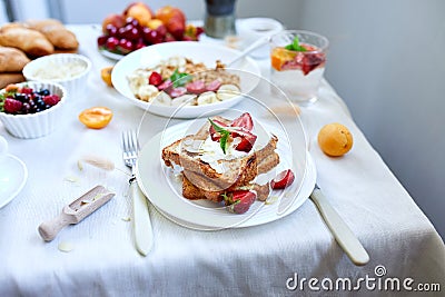 Fresh and bright continental breakfast table, abundance healthy meal variety crunch cereal, french toast, fruits, lemonade, coffee Stock Photo