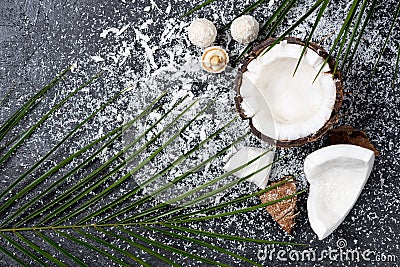 Fresh broken coconut with shavings on black Stock Photo