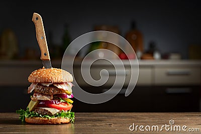 Fresh burger with knife on a kitchen table Stock Photo