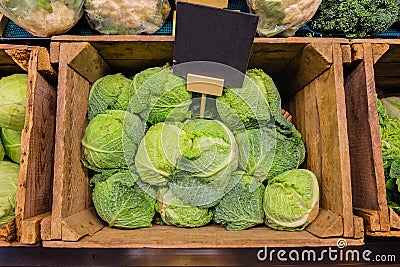 Fresh cabbage vegetable in wooden box stall in greengrocery with price chalkboard label Stock Photo