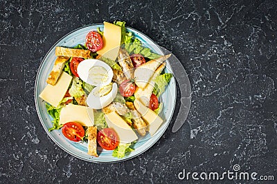 Fresh caesar salad in plate on black stone table. Top Stock Photo