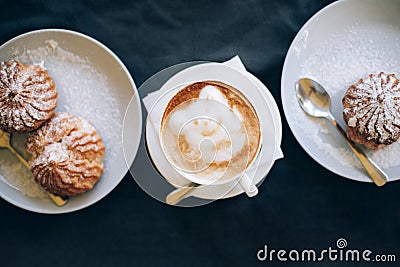 Fresh cappuccino art with two plates with tasty cakes. Stock Photo