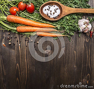 Fresh carrots with cherry tomatoes, garlic and wooden spoon vintage salt and pepper colored it wooden rustic background top vie Stock Photo
