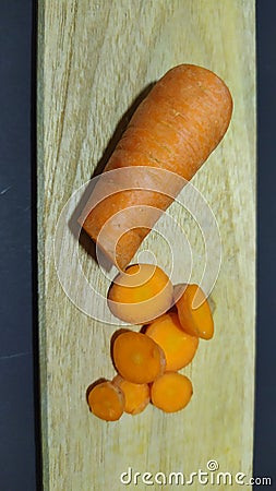fresh carrots on a wooden mat with a black background Stock Photo
