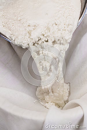 Fresh cheese making process, clotted cheese throw a cotton cloth, closeup Stock Photo