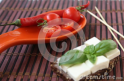 Fresh cherry tomatoes Fresh cherry tomatoes green basilicas and cheese on toast. Stock Photo