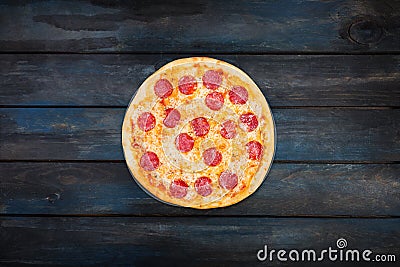 Fresh classic pepperoni pizzai on a dark wooden background. Top view center orientation Stock Photo