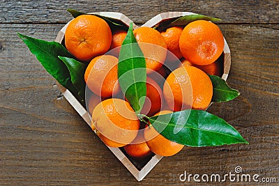 Fresh clementine in a heart shaped box on a wooden background Stock Photo