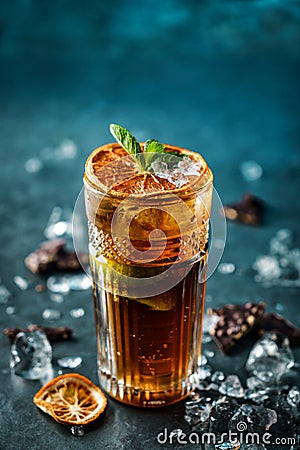 Fresh cocktail with cola, lime, chocolate and ice in glass on dark blue background. Summer cold drink and cocktail Stock Photo