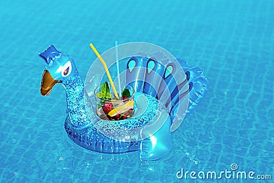 Fresh coctail mojito on inflatable blue peacock toy at swimming pool. Vacation concept Stock Photo