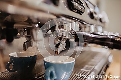 Fresh coffee prepared in the a coffee machine. Espresso in small white cups Stock Photo