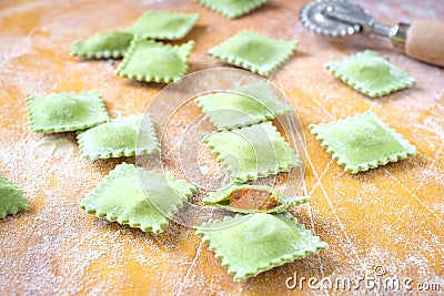 Fresh colored home-made ravioli with spinach on wooden table Stock Photo