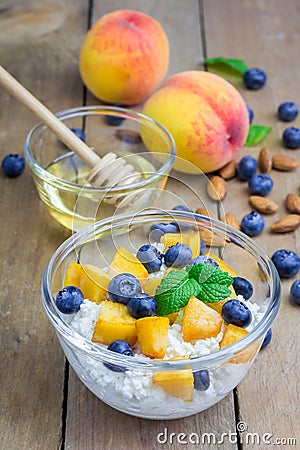 Fresh cottage cheese with peach, blueberry, almonds and honey Stock Photo
