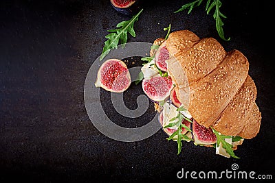 Fresh croissant sandwich with brie cheese arugula and figs. Stock Photo