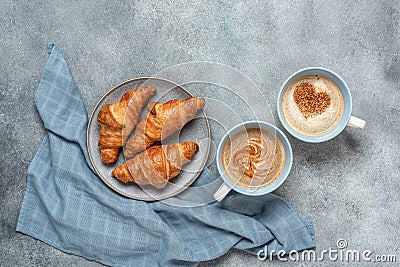 Fresh croissants and a cup of coffee with hearts. Gray grunge background. Top view, copy space Stock Photo