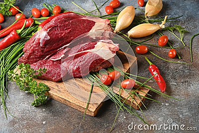 Fresh dark meat with ingredients for cooking on brown wooden cutting board. Stock Photo