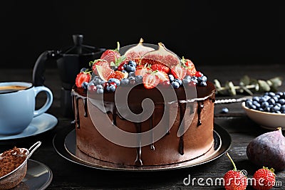 Fresh delicious homemade chocolate cake with berries on table against dark background Stock Photo