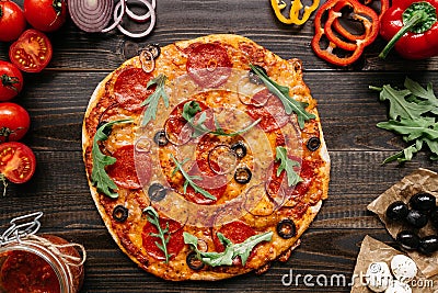 Fresh delisious pizza with pizza ingredients on the wooden table, top view Stock Photo