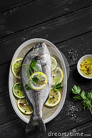 Fresh Dorado fish with lemon, lime and parsley on an oval dish Stock Photo