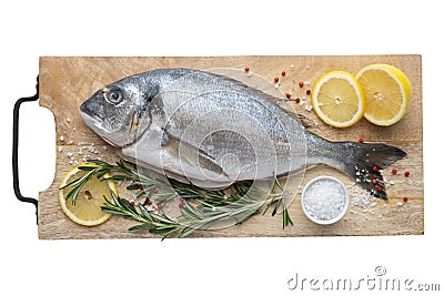 Fresh dorado fish with lemon slices, salt and rosemary on cutting board. Top view, . Stock Photo