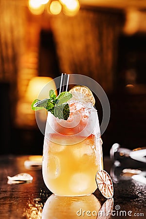 Fresh drink with lemon, orange and ice in glass jar on backdrop of the restaurant atmosphere. Summer drinks and cocktails Stock Photo