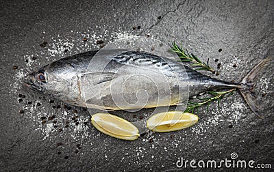 Fresh fish with herbs spices rosemary and lemon - Raw fish seafood on black plate background top view , Longtail tuna , Eastern Stock Photo