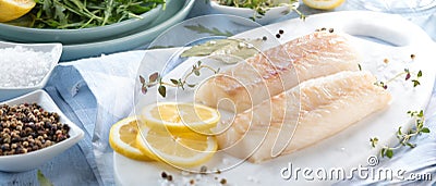 Fresh fish, raw cod fillets with addition of herbs and lemon. Stock Photo