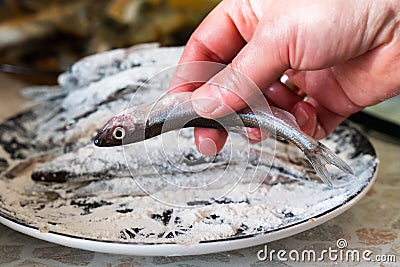 Fresh fish of the smelt rolled in flour. the process of cooking food Stock Photo