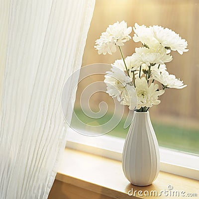 Fresh flowers in vase on windowsill with sheer fabric curtains window coverings. Simple, natural, home interior decor. Stock Photo