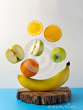 Fresh flying fruit on a blue-white background. Oranges, apples, banana. Stock Photo