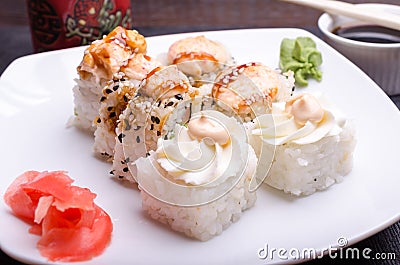 Cut sushi rolls on a platter with ginger and wasabi Stock Photo