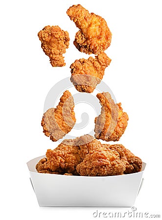 Fresh fried chicken falling into container on white background Stock Photo